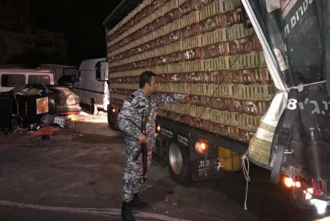 أحد أفراد الضابطة الجمركية يتفقد الشاحنة المهربة ضبط 6500 دجاجة مهربة من المستوطنات في رام الله