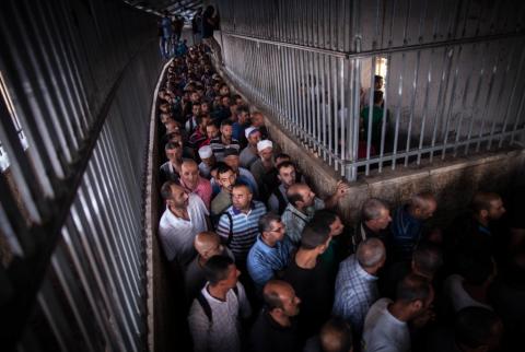عمال فلسطينيون في طريقهم إلى العمل في إسرائيل عبر حاجز في بيت لحم-أرشيف وكالات هل ستتمكن الحكومة من وقف ظاهرة سماسرة تصاريح العمال؟