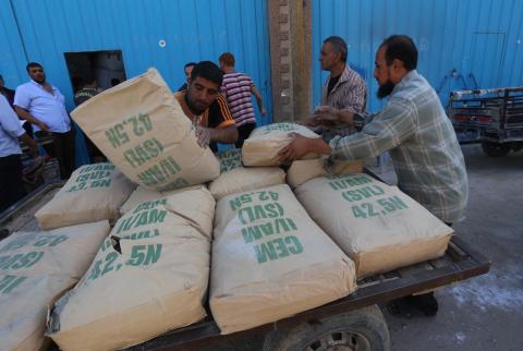 صورة أرشيفية-عمال فلسطينيون يحملون أكياس اسمنت في غزة-تصوير ا ب ا إسرائيل توقف إدخال الاسمنت وتخفض تصاريح تجار غزة