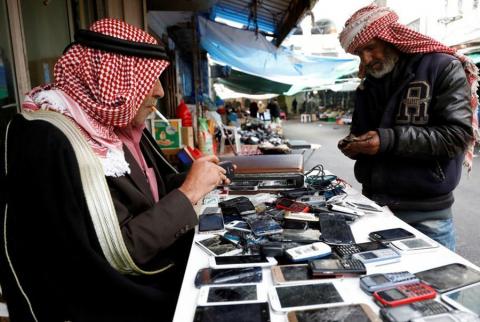مواطن يبيع هواتف خلوية مستعملة وسط رام الله-أرشيف رويترز %97 من الأسر الفلسطينية تمتلك خط هاتف نقال واحد على الأقل