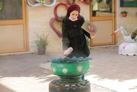 الخليل - رنا الخطيب (20 عاما) من مدينة الخليل تعمل في منزلها على إعادة تدوير إطارات السيارات التالفة، لتصنع منها أحواضا لزراعة الزهور-تصوير مشهور وحواح شابة تصنع من الإطارات التالفة أحواضا للزراعة