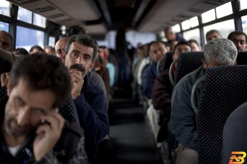 عمال فلسطينيون يستقلون حافلة إسرائيلية في طريقهم لأماكن عملهم-تصوير Getty Images وزارة العمل: نلاحق سماسرة التصاريح وحولنا ملفات للقضاء