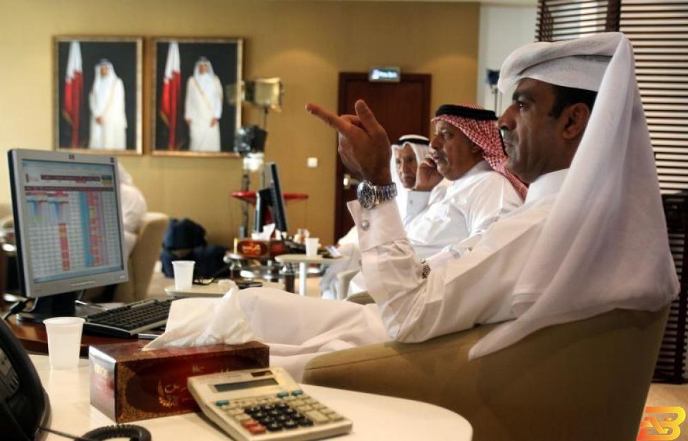 متعاملون أثناء التداول في بورصة قطر في الدوحة - صورة من أرشيف رويترز. قطر تقود خسائر بورصات الخليج وسهم قطر الوطني يتراجع من مستوى مرتفع