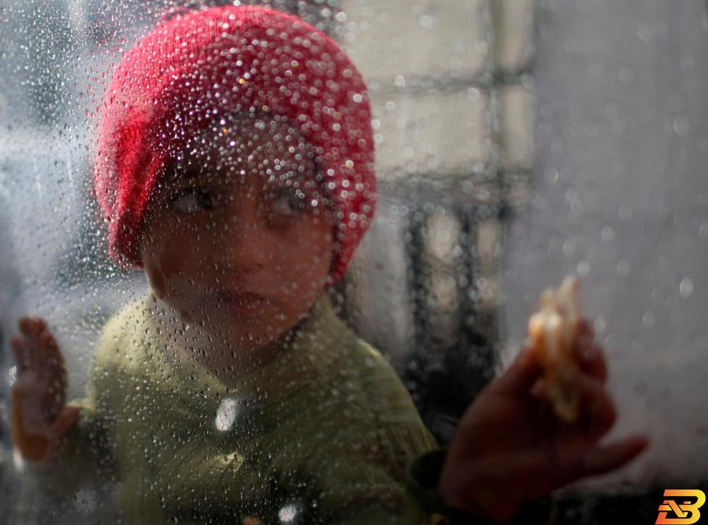 طفلة فلسطينية تنظر إلى تساقط الأمطار في مخيم الشاطئ بقطاع غزة-تصوير رويترز محللون: فلسطين تتعرض لحصار مالي لإخضاعها للقبول بـ’صفقة القرن’