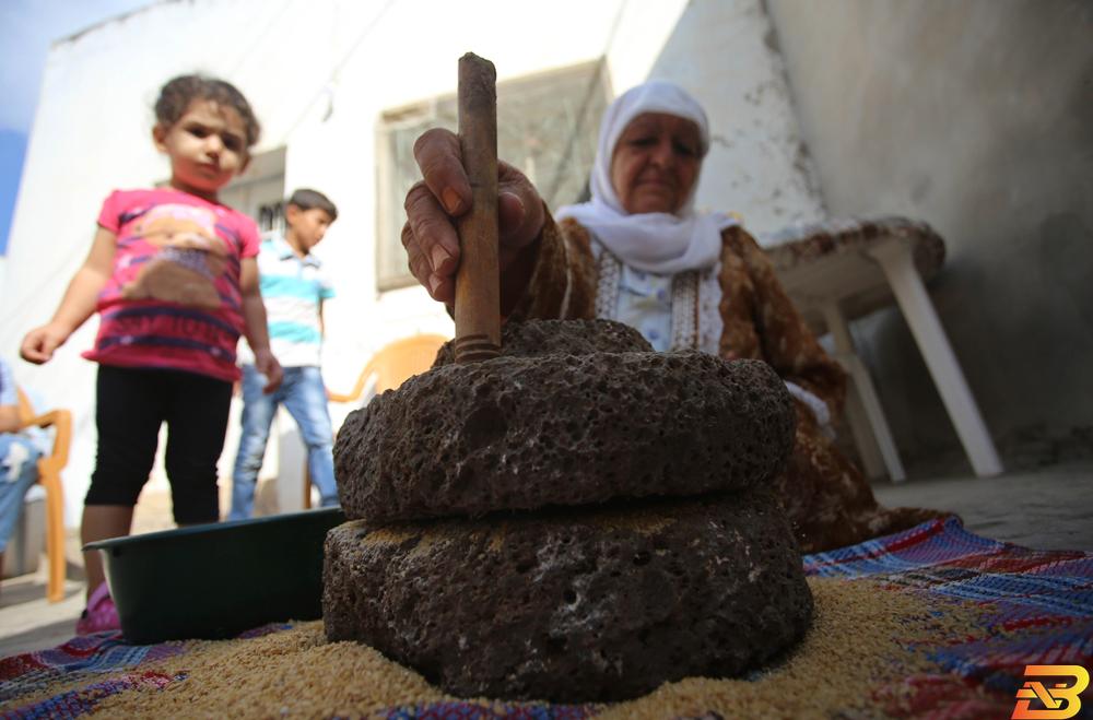 سهام ابو الرب تطحن حبوب القمح باستخدام الجاروشة (الرحى) داخل منزلها في قرية جلبون (عدسة: ايمن نوباني/وفا) الرحى التي تدور في حياة الفلسطينيين