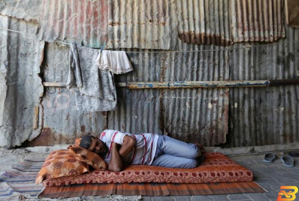 صورة توضيحية-رجل ينام أمام منزله المصنوع من "الزينغو" في خانيونس-أرشيف رويترز توالي انهيار شركات القطاع الخاص في غزة