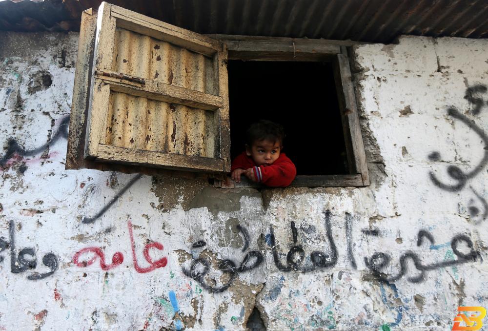 صورة توضيحية-طفل فلسطيني يطل من شباك منزله في مخيم خانيونس للاجئين بقطاع غزة-أرشيف رويترز 130م2 متوسط مساحة المسكن في فلسطين للعام 2017