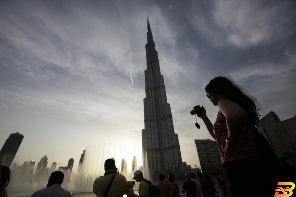 سائحون يلتقطون صورا لبرج خليفة في دبي - صورة من أرشيف رويترز. بيانات: نمو سياحة دبي قليلا في 2018 وزيادة الزائرين الصينيين 12%