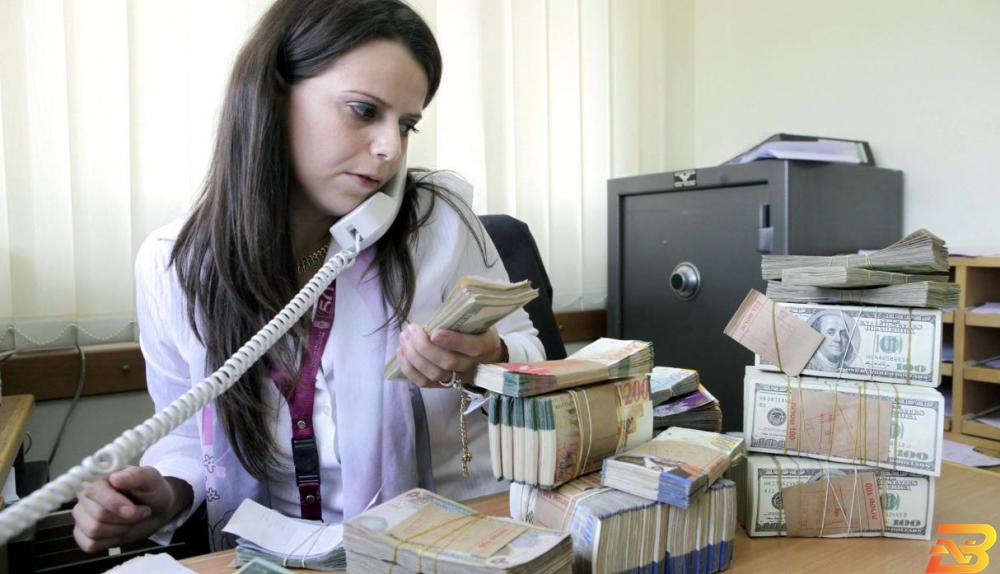 صورة وتوضيحية-موظفة تعد نقوداً في بنك فلسطين-أرشيف وكالات 1.66 مليار دولار صافي رصيد الاستثمار الدولي الفلسطيني حتى نهاية 2018