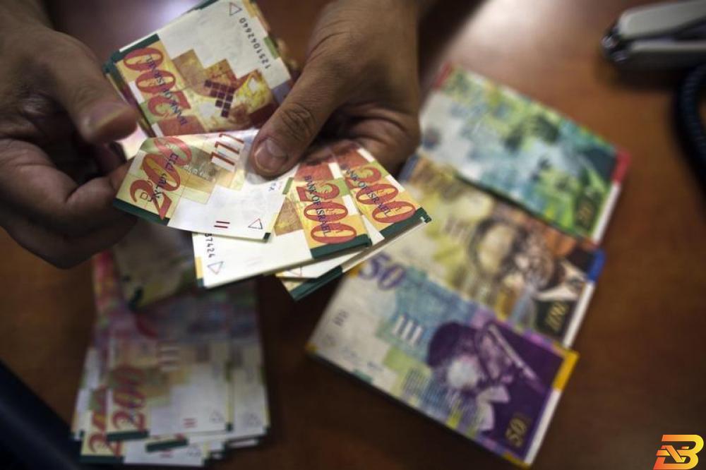 موظف بنك يعد أوراق نقدية من عملة الشيكل في تل أبيب-أرشيف رويترز غلوبس: الشيكل يكسب رغم التوتر على حدود غزة