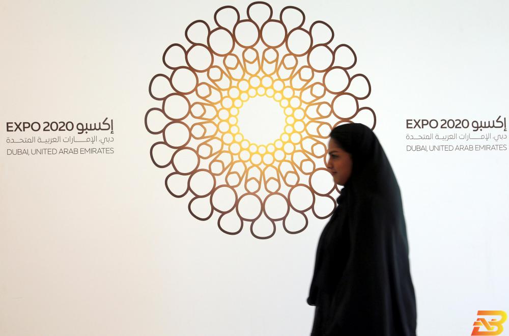 امرأة تمر أمام شعار معرض إكسبو 2020 في صورة من أرشيف رويترز. منظمون: إكسبو دبي 2020 سيجتذب 11 مليون زائر أجنبي