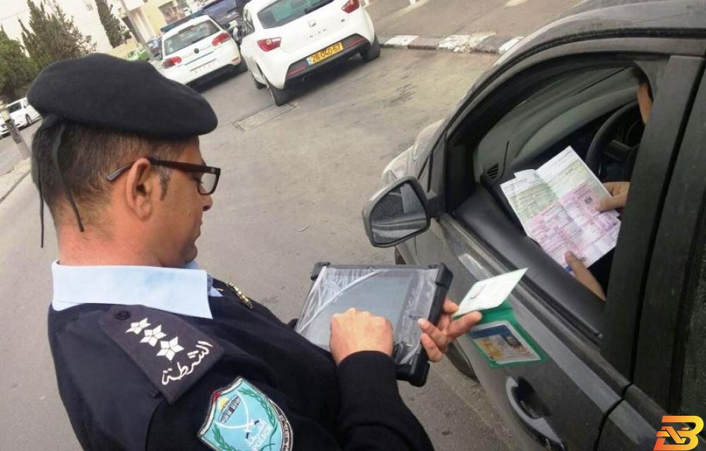 شرطي يدقق في أوراق مركبة-صورة توضيحية سلطة الترخيص: سحب رخصة قيادة كل من يتم ضبطه يقود مركبة غير قانونية