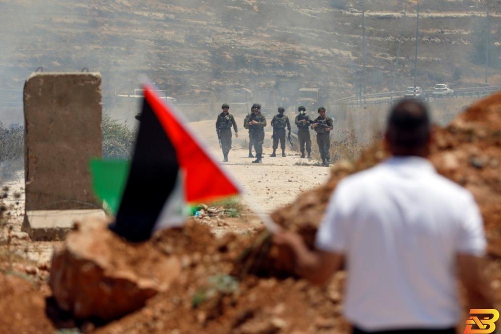 متظاهر يلوح بالعلم الفلسطيني أمام جنود إسرائيليين خلال احتجاج ضد مؤتمر المنامة في الضفة الغربية المحتلة يوم 25 يونيو حزيران 2019. تصوير: محمد تركمان - رويترز الفلسطينيون يرفضون الحلول الاقتصادية من أمريكا
