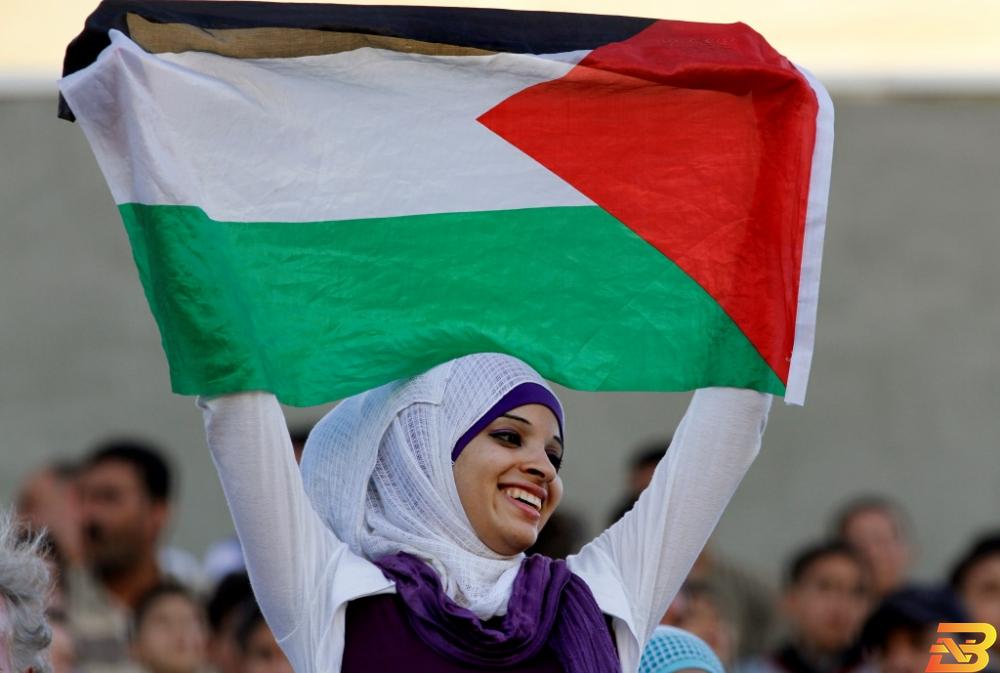 صورة توضيحية-شابة ترفع العلم الفلسطيني-أرشيف وكالات 13 مليونا تعداد الفلسطينيين في العالم