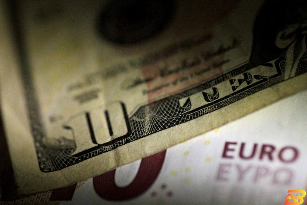 ورقتا نقد من الدولار واليورو في صورة توضيحية من أرشيف رويترز الدولار يرتقع قبل كلمة رئيس مجلس الاحتياطي الاتحادي