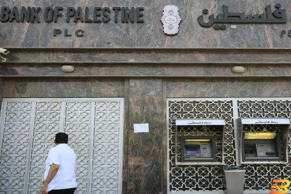 مواطن يمر أمام فرع لبنك فلسطين في قطاع غزة-أرشيف وكالات المصارف في قطاع غزة تفتح أبوابها من جديد