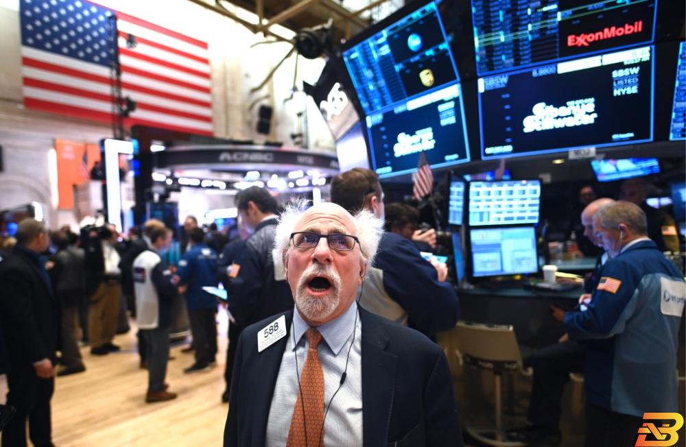 متعاملون في بورصة نيويورك للأوراق المالية (NYSE)-تصوير وكالات هل ستتسبب كورونا في انخفاض فائدة الدولار الأمريكي قريبا؟