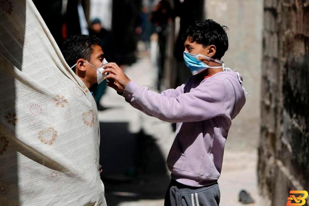 طفلان يرتديان الكمامات الواقية في مخيم الشاطئ بقطاع غزة-تصوير أ ف ب لا إصابات جديدة وعدد المتعافين يصل إلى 100