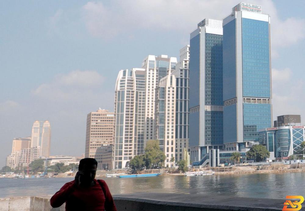 رجل يسير على ضفة نهر النيل أمام عدد من الفنادق المطلة على النهر-تصوير رويترز مصر تسمح بإعادة فتح الفنادق أمام السياحة الداخلية