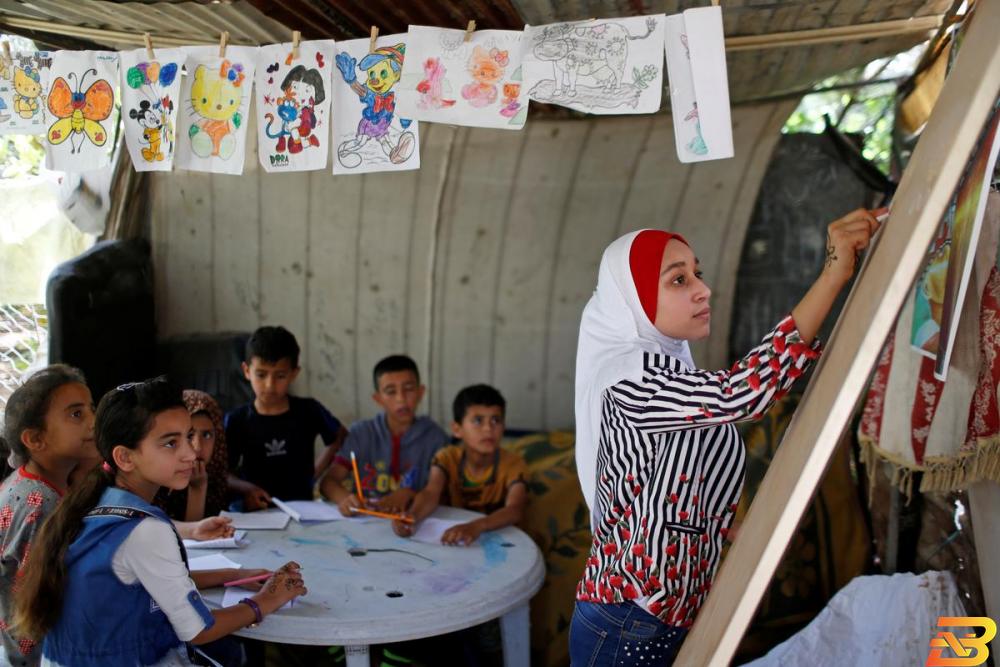 الطالبة الفلسطينية فجر حميد (13 عاما) تدرس لجيرانها اللغة العربية في قطاع عزة نظرا لغلق المدارس جراء فيروس كورونا يوم الثلاثاء. تصوير: محمد سالم - رويترز تلميذة في غزة تعلم أطفال الحي خلال إغلاق المدارس