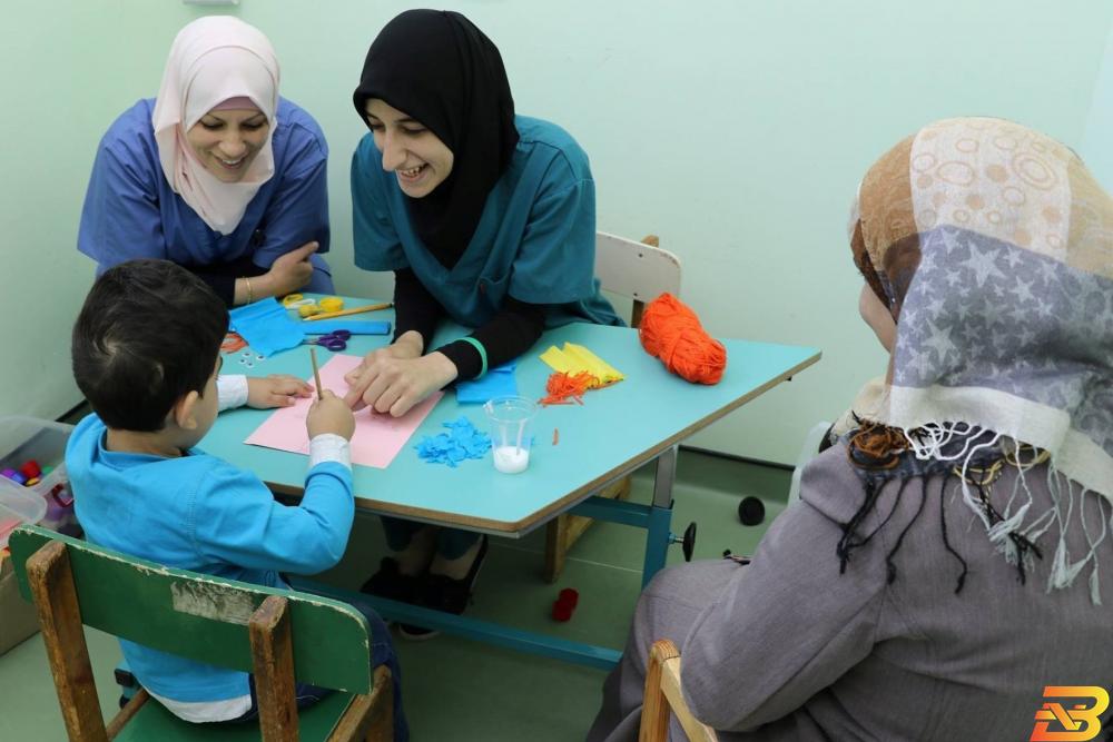 ممرضتان تتواصلان مع طفل من مراجعي المؤسسة مؤسسة ’الأميرة بسمة’ تواجه عجزاً مالياً بعد تراجع إيراداتها 50%