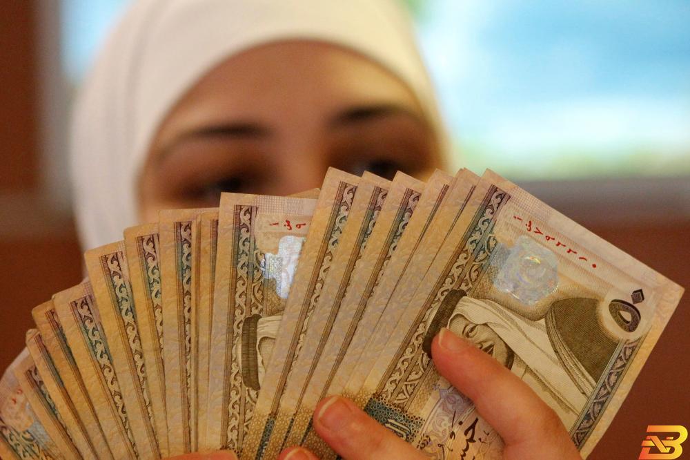 موظفة بنك في العاصمة الأردنية عمان تعد أوراق نقدية بعملة الدينار-تصوير رويترز نمو تسهيلات البنوك الأردنية للقطاع الخاص 4% في النصف الأول
