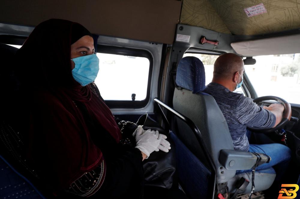 إمرأة فلسطينية تضع كمامة للوقاية من فيروس كورونا في سيارة أجرة في رام الله يوم 21 يونيو حزيران 2020. تصوير: محمد تركمان - رويترز 4 وفيات و553 إصابة جديدة بالكورونا