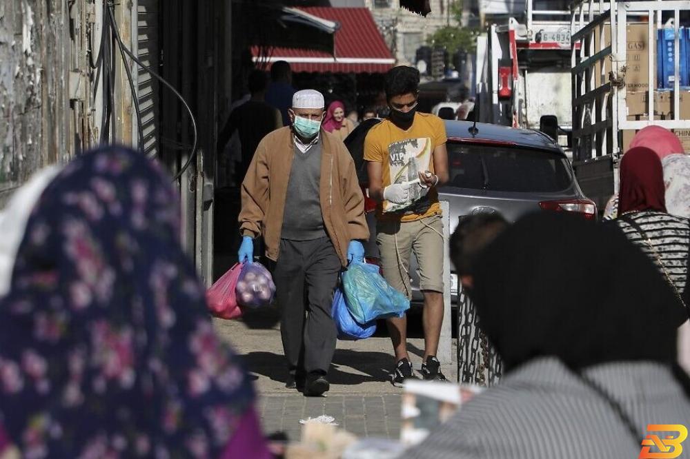 متسوقون يرتدون كمامات للوقاية من فيروس كورونا وسط رام الله-تصوير وكالات البنك الدولي: 2020 عام صعب للغاية للاقتصاد الفلسطيني