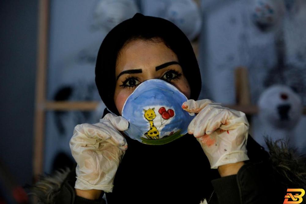 الفنانة الفلسطينية سماح سعيد ترتدي كمامة ملونة ضمن مشروع لرفع مستوى الوعي حول جائحة فيروس كورونا COVID-19 في مدينة غزة-تصوير أ ف ب دراسة ألمانية: الكمامات تقلل خطر الإصابة بكورونا بنسبة 45%