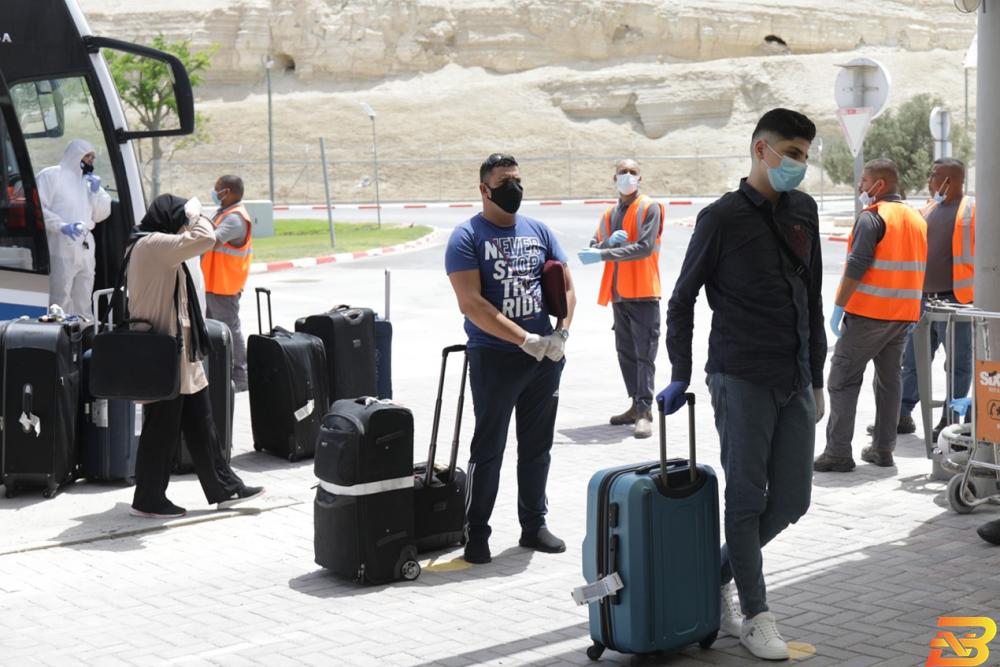 صورة توضيحية-مواطنون يرتدون الكمامات خلال عودتهم من الأردن عبر جسر الملك حسين الحكومة تدرس مع الجانبين الأردني والإسرائيلي إغلاق الجسور